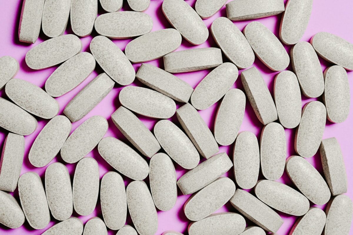 white medication pills isolated on purple background